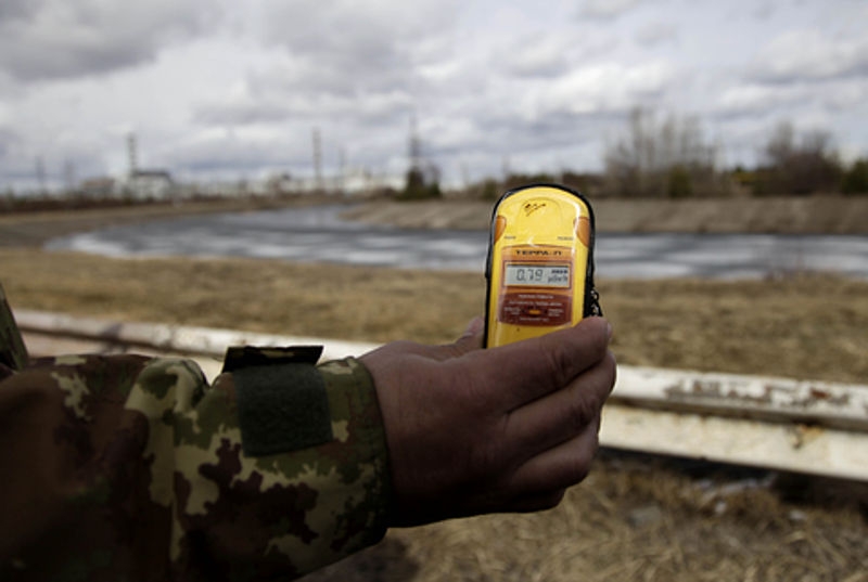 A tour guide measures radiation at the site of Chernobyl.